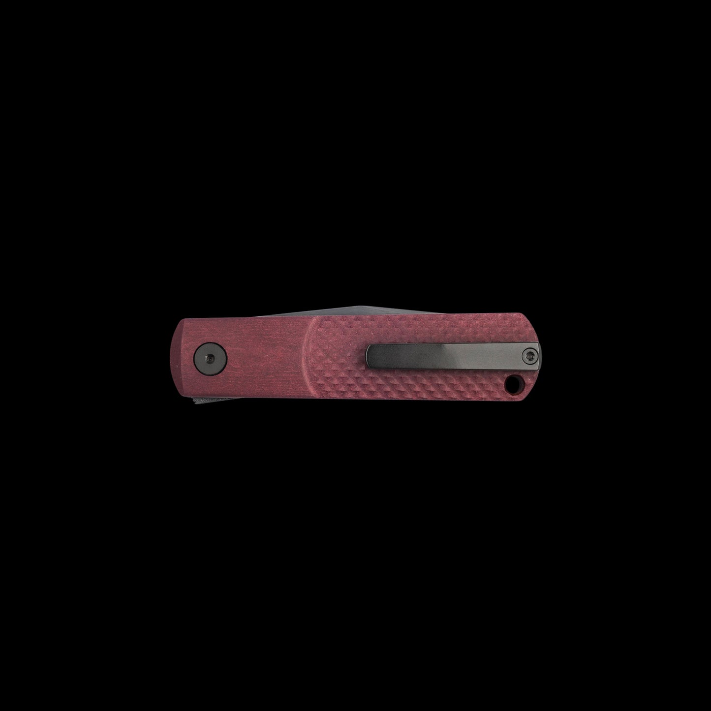 A folding pocket knife with a textured reddish-pink handle and a dark gray metal clip, shown horizontally against a solid black background.