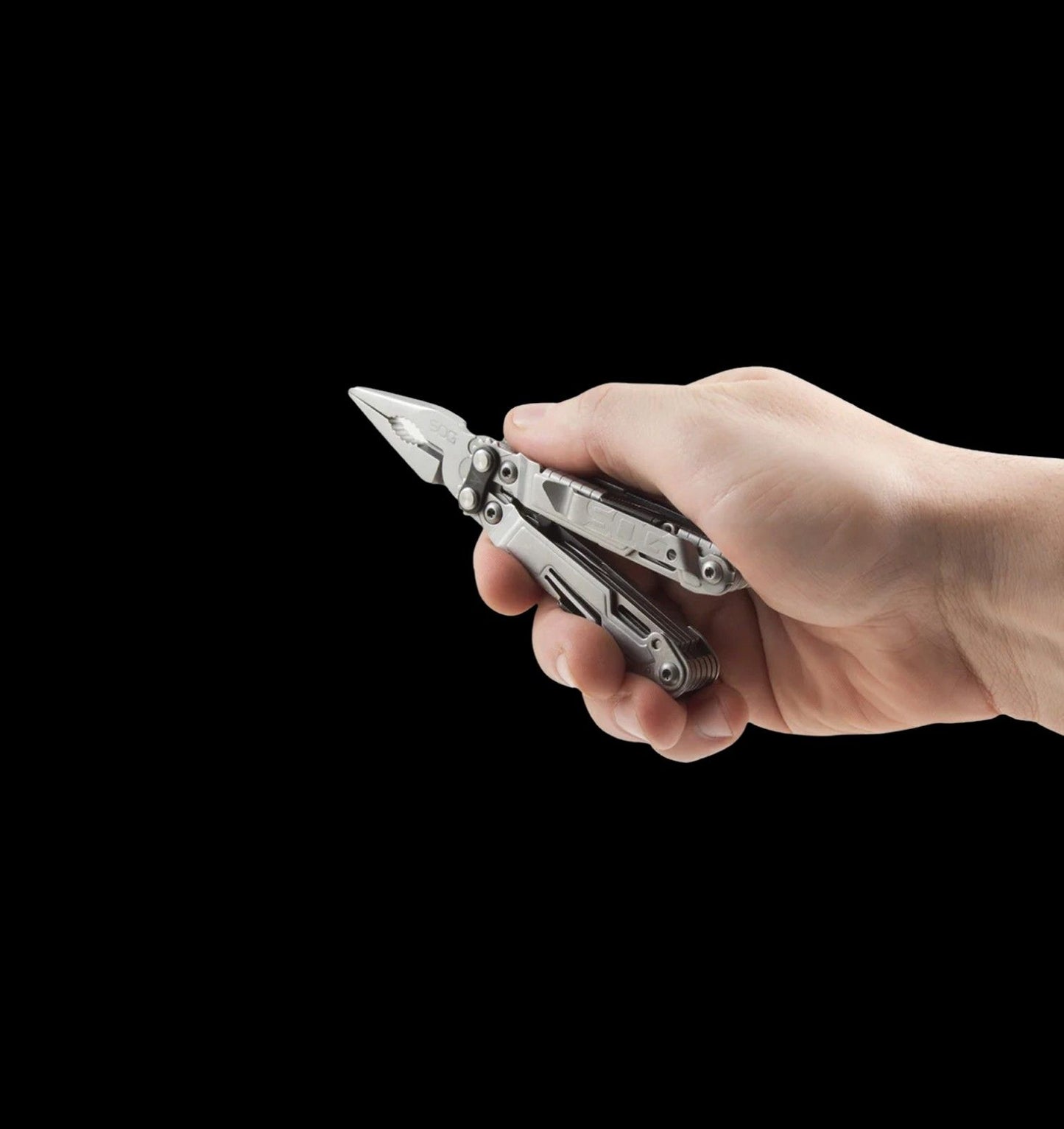 A hand holding a silver multi-tool with pliers on the right side against a solid black background.