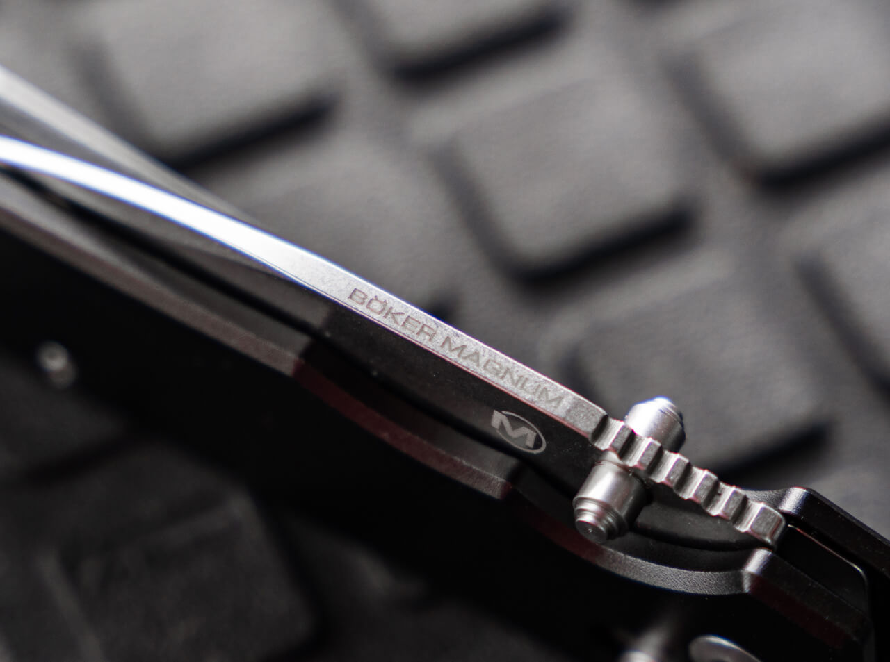 Boker Magnum knife blade on a textured black background