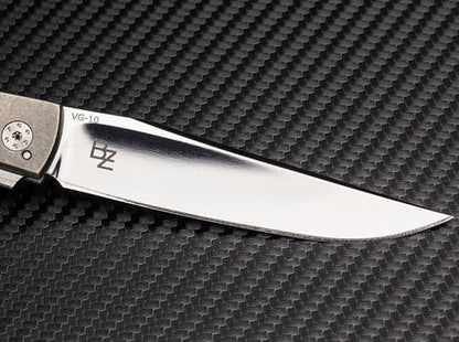 Knife blade with 'BZ' branding on a carbon fiber background