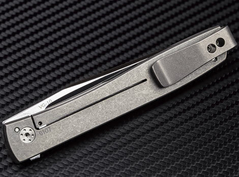 Folding knife with a metallic finish on a textured black background