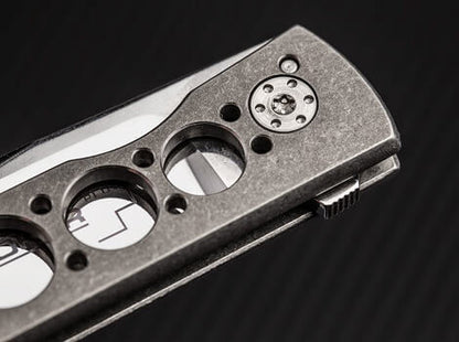 Close-up of a metallic tool with circular cutouts on a dark background