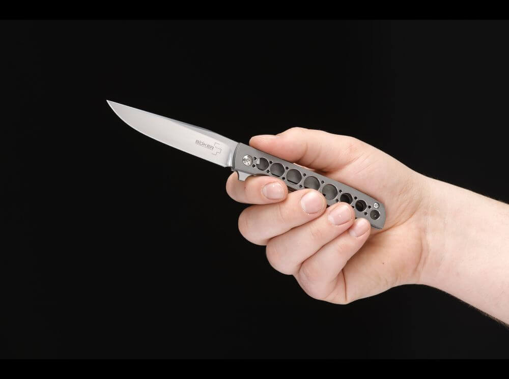 Hand holding a pocket knife with a black background
