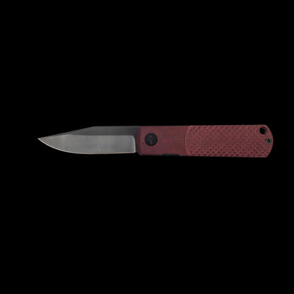 A folding pocket knife with a satin-finished steel blade and a textured reddish-brown handle, shown horizontally against a solid black background.