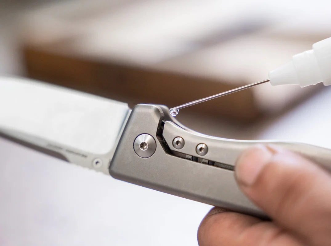 Close-up of a person holding a folding knife with a blurred background