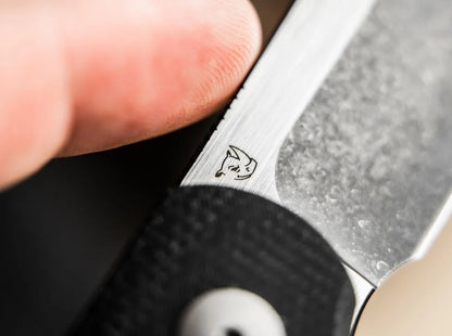 Close-up of a pocket knife with a brand logo on the blade