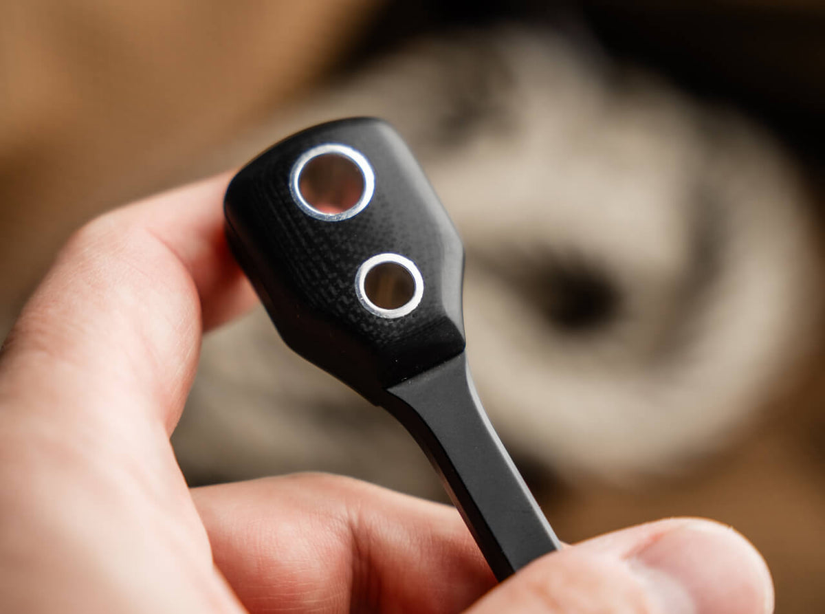 Close-up of a hand holding a car key fob with a blurred background