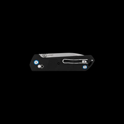 A black folding pocket knife with a silver blade, featuring blue and white circular accents on the handle, shown against a solid black background.