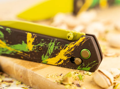 Folding saw with a colorful handle on a wooden surface