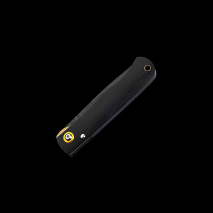 A black folding pocket knife shown open at an angle against a solid black background, featuring a yellow and black logo and a silver rivet on the handle.
